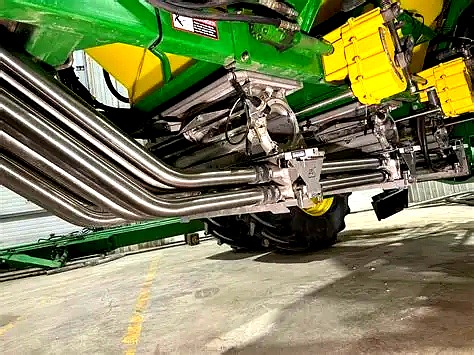 Stainless steel seed tubes on the undercarriage of a John Deere air seeder