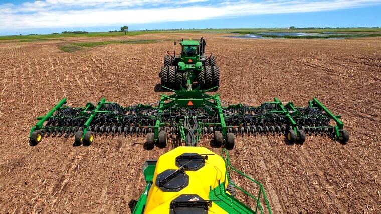 John Deere air seeder and seed cart working a Minnesota field — aerial view